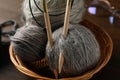 Wicker bowl with yarn balls and knitting needles, and glasses on wooden background Royalty Free Stock Photo