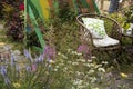 Wicker chairs in garden near the table with a vase with plants