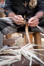 Old wicker craftsman with hands working in isolated foreground