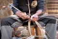 Old wicker craftsman with hands working in isolated foreground