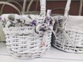 Wicker decorative baskets on a shelf in a store. Pretty baskets painted white. Textile bag. Stylish gift for Easter