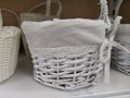 Wicker decorative baskets on a shelf in a store. Pretty baskets painted white. Textile bag. Stylish gift for Easter