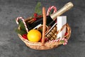 Wicker gift basket with sparkling wine and Christmas decor on grey textured table Royalty Free Stock Photo