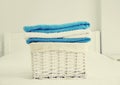 Wicker laundry basket with clean folded towels on the bed Royalty Free Stock Photo