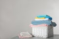 Wicker laundry basket with clean towels on table against light background Royalty Free Stock Photo