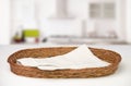Wicker oval basket with a cotton beige napkin inside on a white table