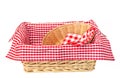 Wicker oval basket with a red checkered napkin isolated on white background