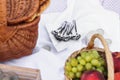 Wicker picnic basket with food and a white tablecloth on the sand at the beach. picnic background concept Royalty Free Stock Photo