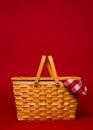 A wicker picnic basket with red gingham tablecloth on a red back Royalty Free Stock Photo