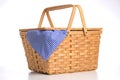 Wicker picnic basket on a white background with blue gingham tablecloth Royalty Free Stock Photo