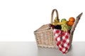 Wicker picnic basket with wine and different fruits on white background Royalty Free Stock Photo