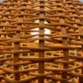 Wicker or rattan lamp shade with a woven pattern, allowing light to filter through. The Royalty Free Stock Photo