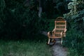 Wicker rocking chair made of rattan. old rocking chair made of wood. stands on the road in the forest. handmade Royalty Free Stock Photo