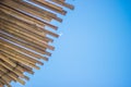 Wicker roof beach umbrella and blue sky. Natural bamboo sunshades and summer umbrella parasol on blue sea shore Royalty Free Stock Photo