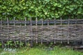 Wicker rustic wooden fence made of sticks in the courtyard in the Alpine village, Austria Royalty Free Stock Photo