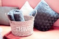 Wicker storage basket with woolen blanket inside and cushions