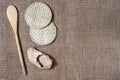Wicker straw stands, bast shoes and wooden spatula on gunny background. Flatlay, topview, copyspace, minimalism, natural eco