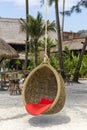 Wicker swing with a pillow hanging on a coconut palm next to the sea on the sand beach. Island Koh Kood, Thailand Royalty Free Stock Photo