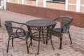 . Wicker table and chairs in empty cafe on the street in the city Royalty Free Stock Photo