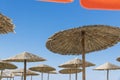 Wicker and textile orange umbrellas on the beach.