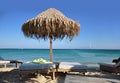 The wicker umbrella on the beach, the blue sky and the sea.