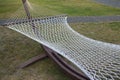 Wicker white empty hammock on a green lawn of a park. Serenity and relaxation in the fresh air. Royalty Free Stock Photo