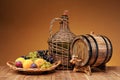 Wicker wine bottle, grapes and wooden barrel Royalty Free Stock Photo