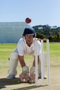 Wicketkeeper looking at ball crouching behind stumps on field Royalty Free Stock Photo