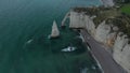 Wide Aerial Establisher of Etretat Cliffs Arch on Overcast Day with dark blue ocean