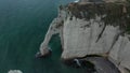 Wide Aerial Establisher of Etretat Cliffs Arch on Overcast Day with dark blue ocean