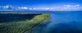 Wide aerial pano of mangroves ocean coastline.