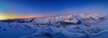 Wide aerial panorama of snowy mountain ridge on winter sunrise. Stunning mountains range covered with snow powder on ski Royalty Free Stock Photo