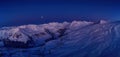 Wide aerial panorama of snowy mountain ridge on winter sunrise. Stunning mountains range covered with snow powder on ski Royalty Free Stock Photo