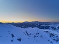 Wide aerial panorama of snowy mountain ridge on winter sunrise. Stunning mountains range covered with snow powder on ski Royalty Free Stock Photo