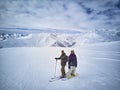 Skier and snowboarder standing on mountain top against blue sky and mountains panorama. Two active friends have vacation Royalty Free Stock Photo