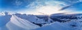 Wide aerial panorama of snowy mountain ridge on winter sunrise. Stunning mountains range covered with snow powder on ski Royalty Free Stock Photo