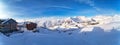 Wide aerial panorama of snowy mountain ridge on winter sunrise. Stunning mountains range covered with snow powder on ski Royalty Free Stock Photo