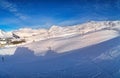 Wide aerial panorama of snowy mountain ridge on winter sunrise. Stunning mountains range covered with snow powder on ski Royalty Free Stock Photo
