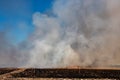 Smoke filled sky with burning farm field, wildfire