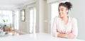 Wide angle of beautiful african american woman with afro hair looking away to side with smile on face, natural expression Royalty Free Stock Photo