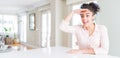 Wide angle of beautiful african american woman with afro hair very happy and smiling looking far away with hand over head Royalty Free Stock Photo