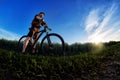 Wide angle of the cyclist standing on the trail on the field against beautiful landscape. Royalty Free Stock Photo