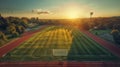 Wide-angle drone shot of a soccer field during sunset, with vibrant sky and shadows