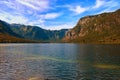 Wide angle landscape view of the Bohinj Lake Bohinjsko jezero and scenic mountain gorge in the background. Royalty Free Stock Photo