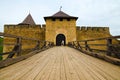 Wide-angle landscape view of the entrance Gate with wooden bridge to the fortress. High stone defensive wall with towers Royalty Free Stock Photo