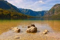 Wide angle landscape view of famous Bohinj Lake Bohinjsko jezero, scenic mountain range against colorful vibrant sky Royalty Free Stock Photo