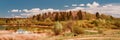 Wide angle large panoramic view on wooded hill and small lake at sunny day