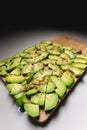 Wide Angle Large slices of sliced ripe avocado lie textured on a wooden cutting board. Sprinkled with spices. Healthy