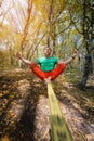 Wide angle male tightrope walker balancing while meditation sitting barefoot on slackline in autumn forest. The concept Royalty Free Stock Photo