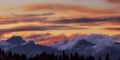 Wide angle panorama silhouette forest and mountain tops in red orange blue clouds gradient sunset